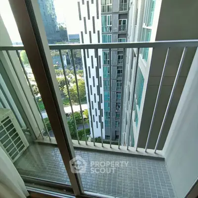 Modern high-rise apartment balcony with city view and sleek railing design.