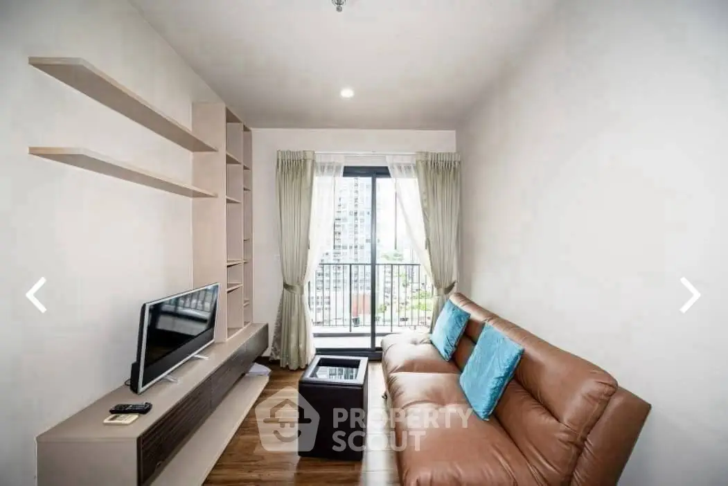 Modern living room with sleek furniture and city view balcony in a stylish apartment.