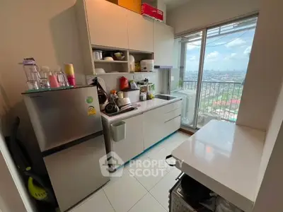 Modern kitchen with city view, featuring sleek cabinetry and stainless steel fridge, ideal for urban living.