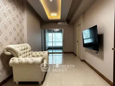 Luxurious living room with elegant white sofa and wall-mounted TV in modern apartment.