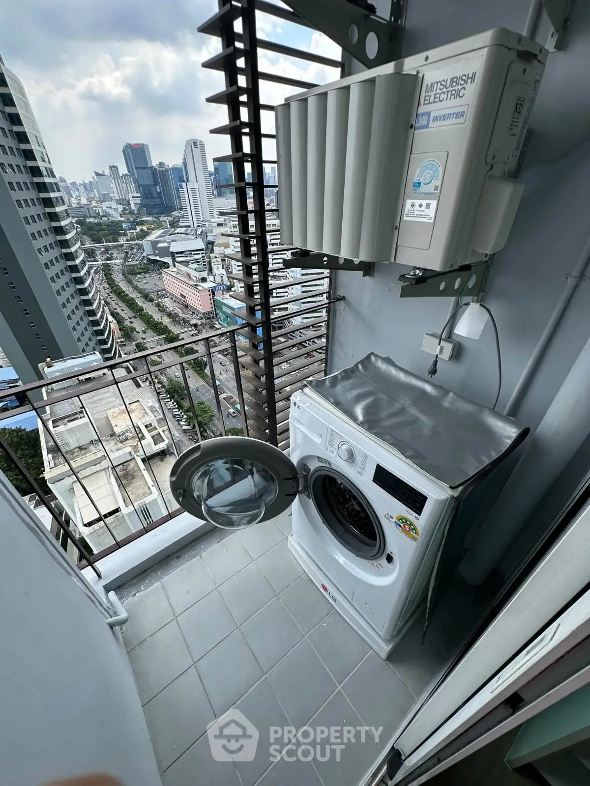 High-rise balcony with washing machine and city view, perfect for urban living convenience.