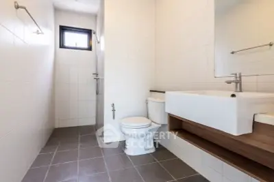 Modern bathroom with sleek fixtures and minimalist design, featuring a spacious layout and natural light.