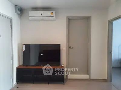 Modern living room with air conditioning and flat-screen TV, perfect for cozy relaxation.