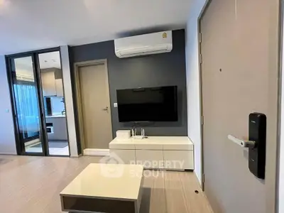 Modern living room with sleek TV setup and open kitchen view