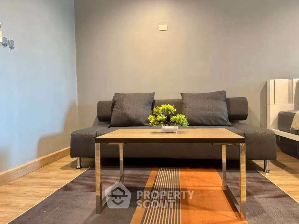 Modern living room with stylish sofa and coffee table on a colorful rug.