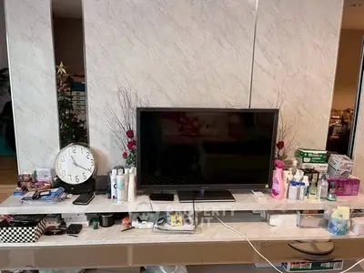 Modern living room with sleek TV setup and decorative elements on marble shelf.