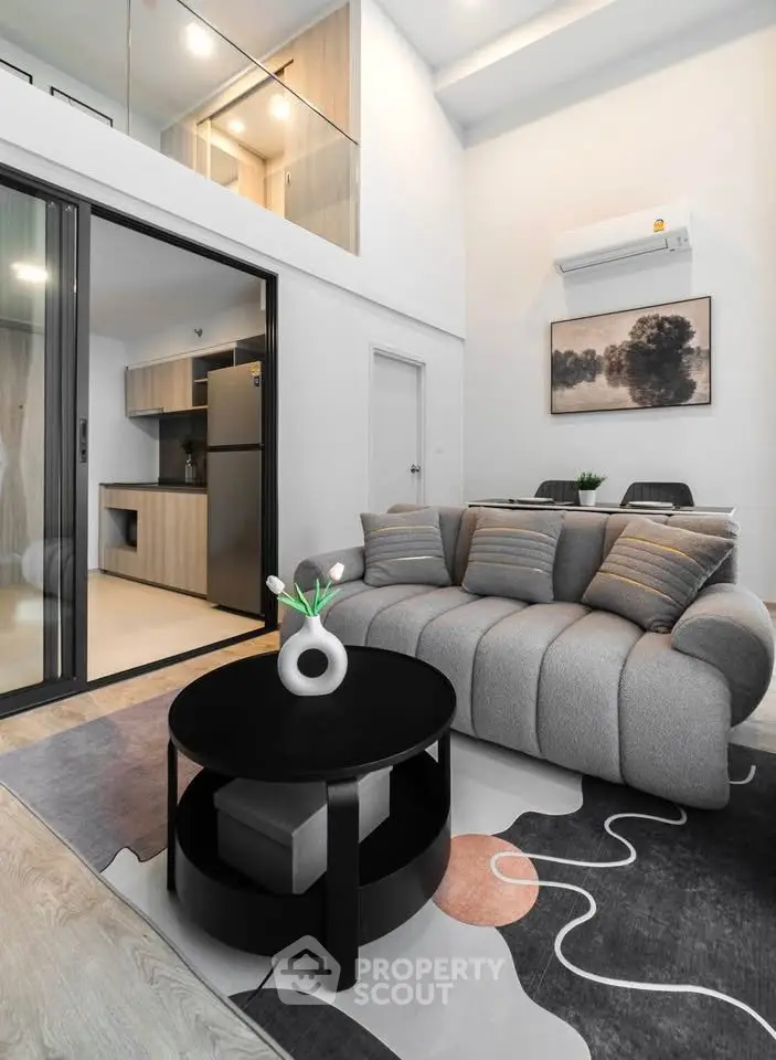 Modern living room with stylish furniture and open kitchen layout in a contemporary apartment.
