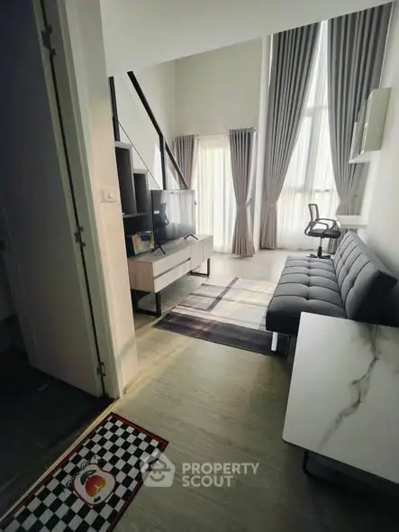 Modern living room with high ceilings and stylish furniture in a contemporary apartment.