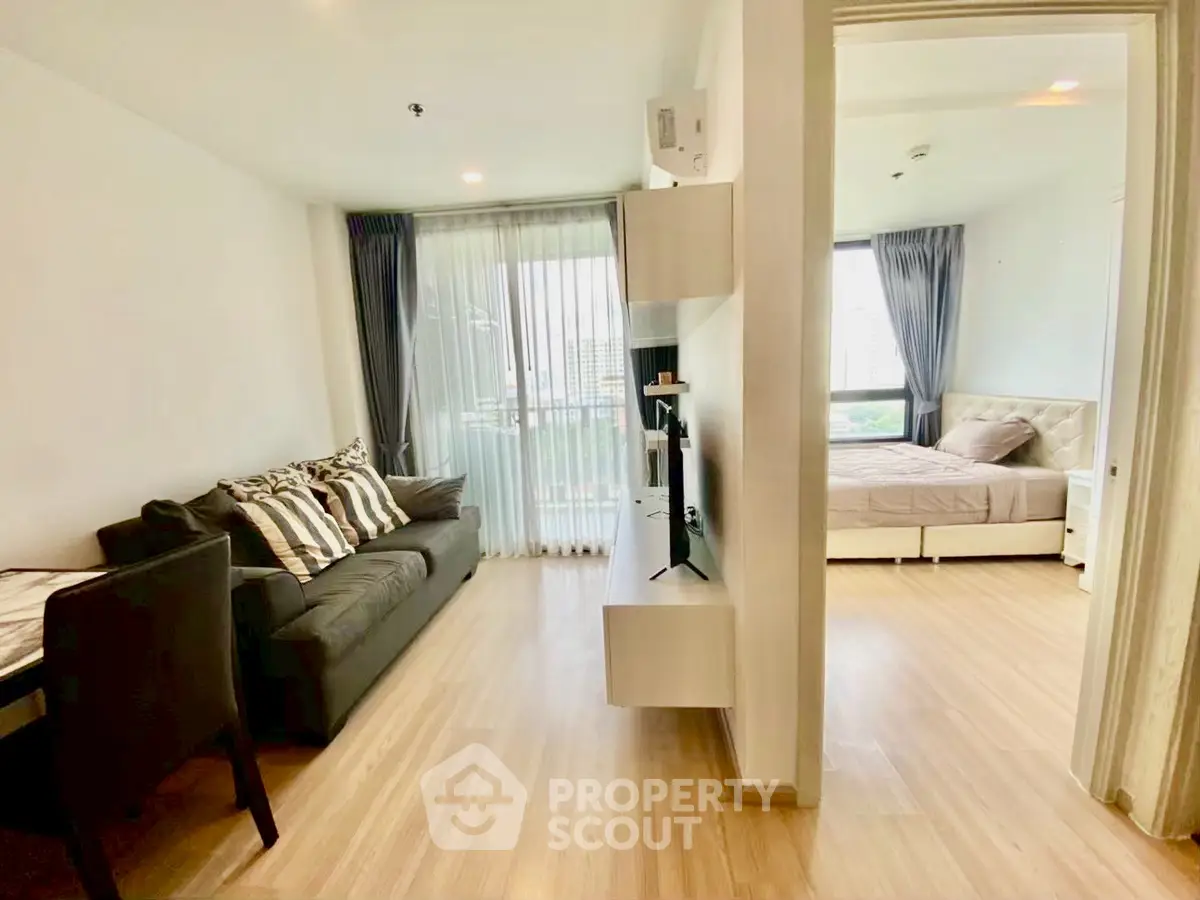 Modern apartment with open living room and cozy bedroom, featuring stylish decor and natural light.
