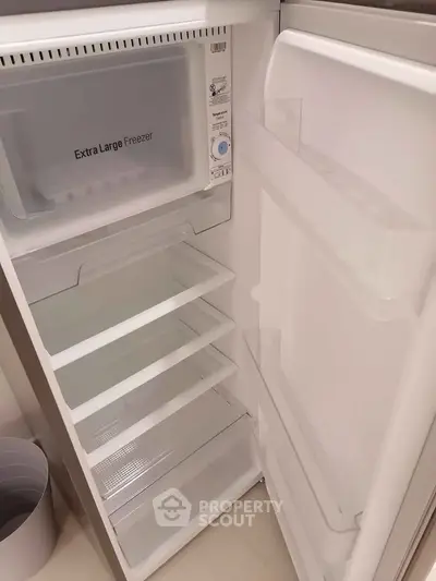 Spacious open fridge with extra large freezer, ideal for modern kitchen convenience.