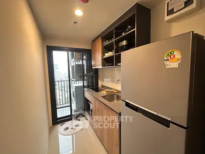 Modern kitchen with balcony view, featuring sleek appliances and ample storage in a high-rise apartment.