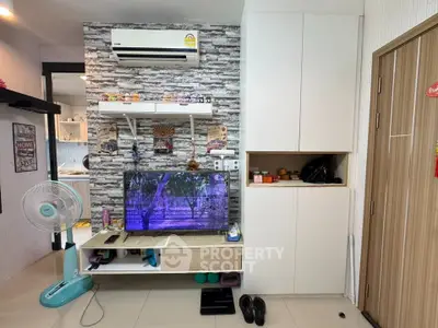 Modern living room with air conditioning and TV unit, featuring stylish decor and ample storage space.