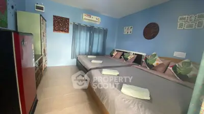 Spacious bedroom with twin beds, modern decor, and natural light.