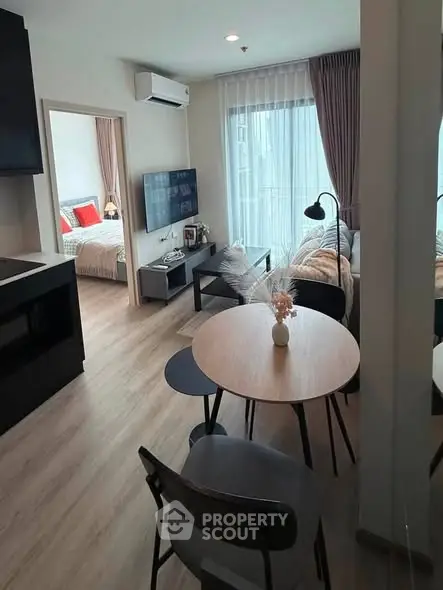 Modern open-plan living room with cozy dining area and bedroom view
