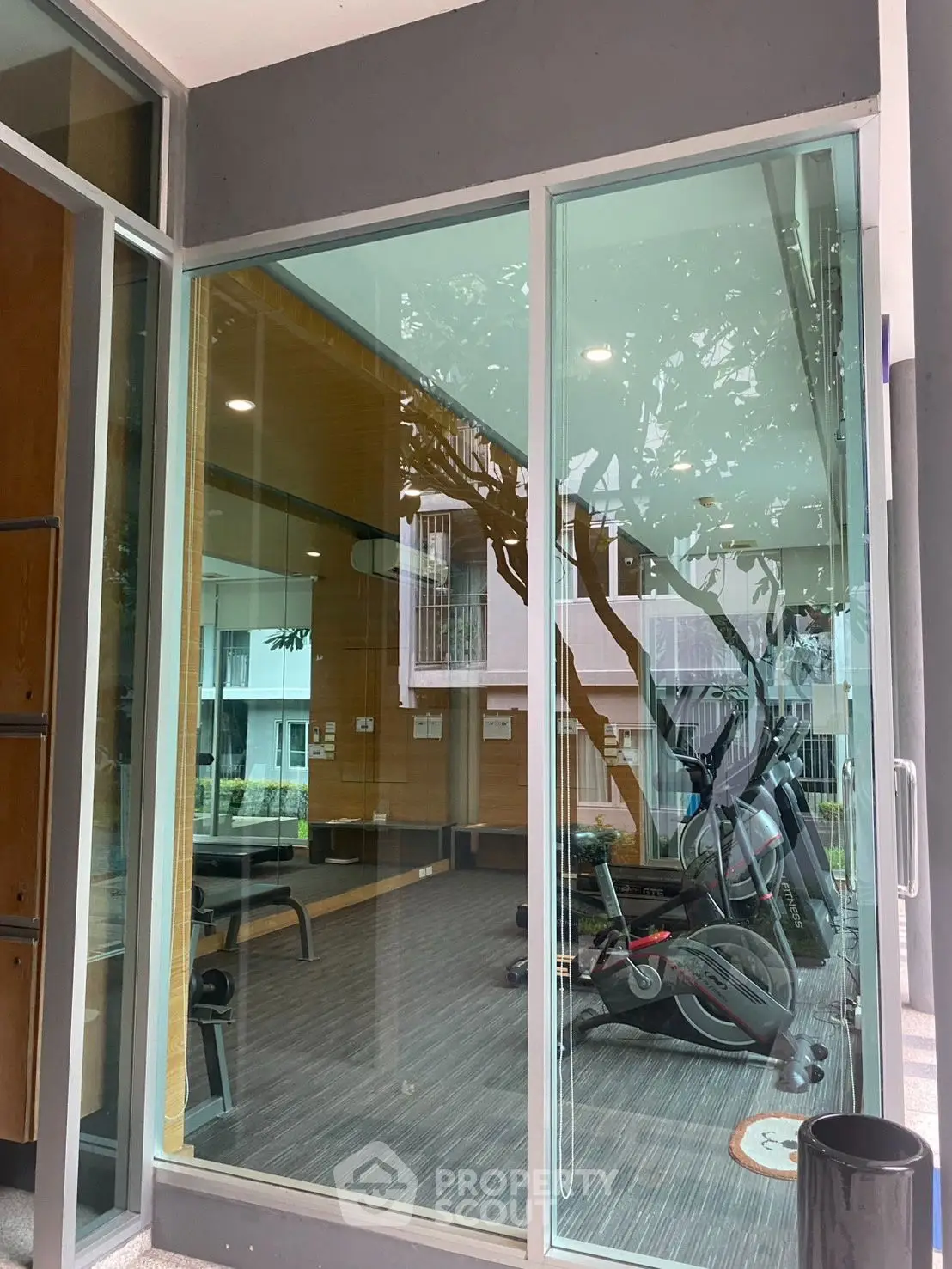 Modern gym with glass walls and exercise equipment in a residential building