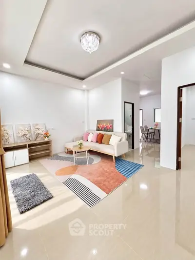 Modern living room with stylish decor and open layout, featuring elegant ceiling design and natural light.