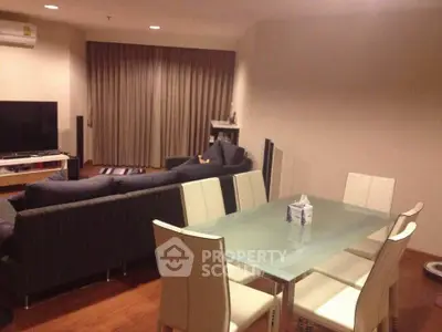Modern living room with sleek furniture and dining area, featuring a cozy ambiance and stylish decor.