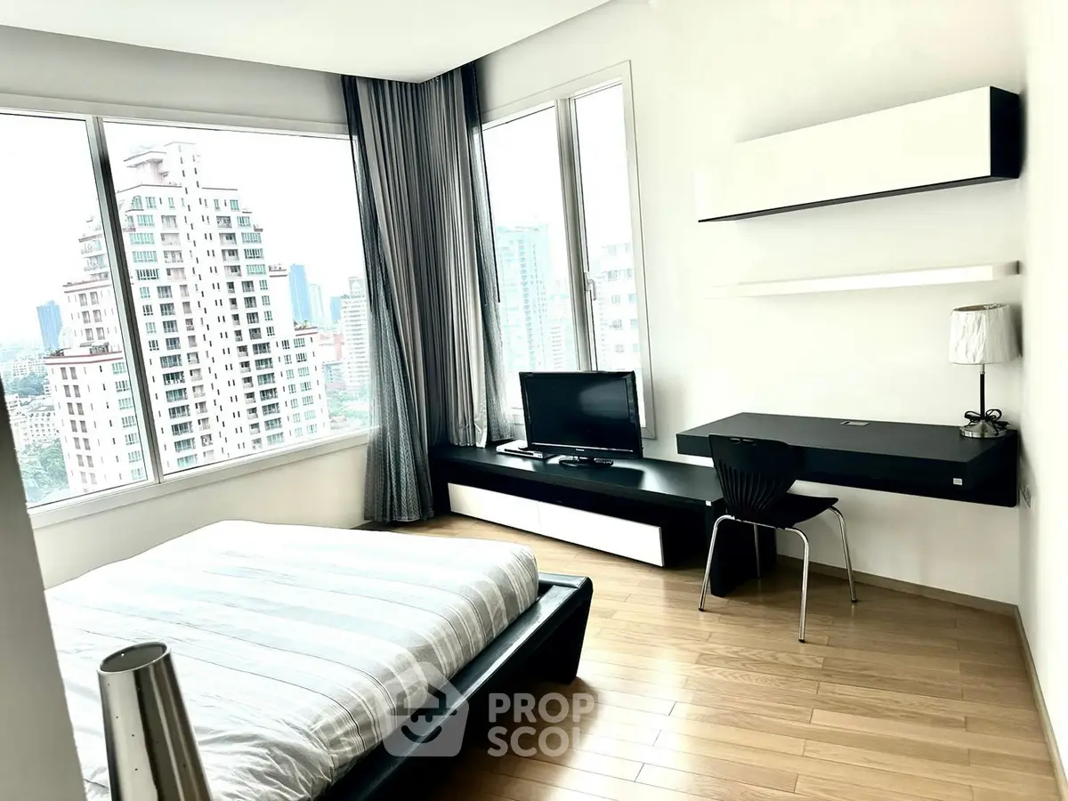 Modern bedroom with city view, sleek furniture, and natural light.
