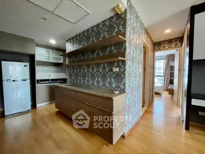 Modern kitchen with wooden flooring and open shelving in stylish apartment