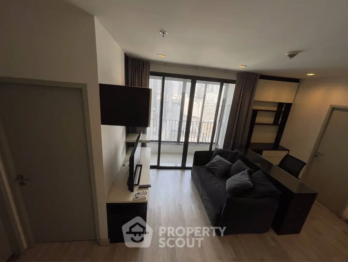 Modern living room with city view, featuring sleek furniture and floor-to-ceiling windows for natural light.