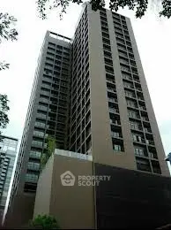 Modern high-rise building with sleek architecture and large windows in urban setting.