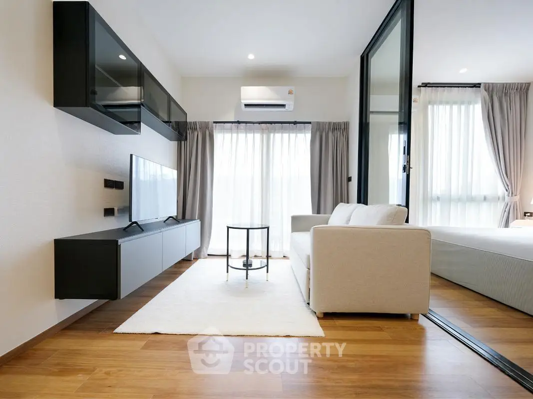 Modern living room with sleek furniture and large windows in a stylish apartment.