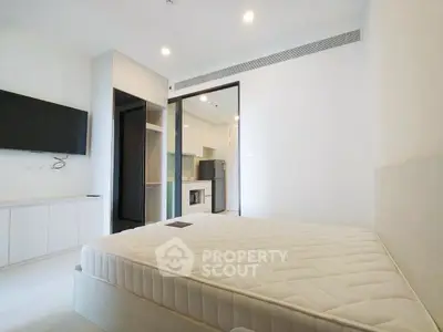 Modern bedroom with minimalist design and open view to kitchen area