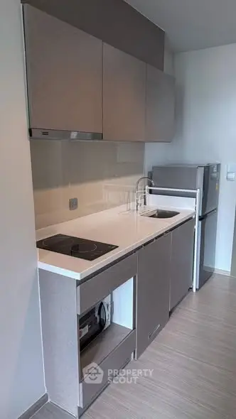 Modern compact kitchen with sleek cabinets and built-in appliances