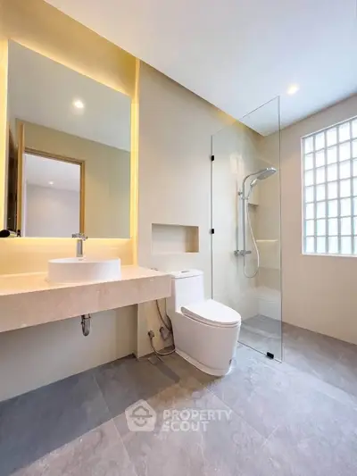Modern bathroom with glass shower and elegant vanity in a contemporary home.