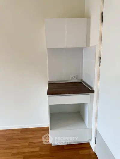 Compact kitchen corner with modern cabinetry and wood flooring