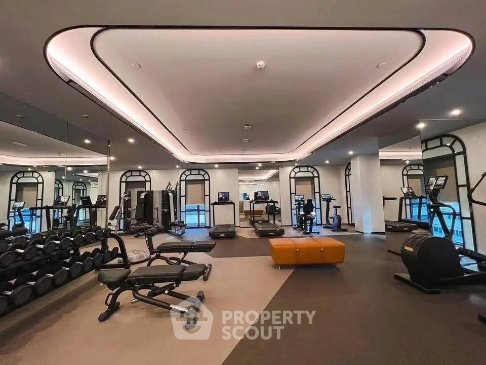 Luxurious modern gym with state-of-the-art equipment and stylish design in upscale residential building.