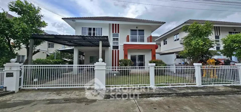 Modern two-story house with gated front yard and carport in suburban neighborhood.