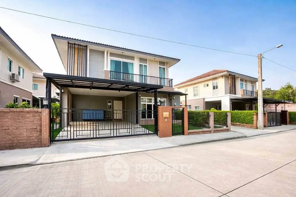 Modern two-story house with sleek design and spacious driveway in a suburban neighborhood.
