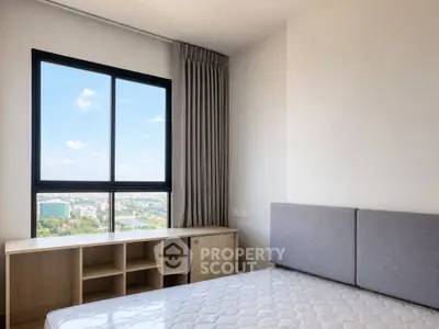 Modern bedroom with large window offering stunning city view and natural light.