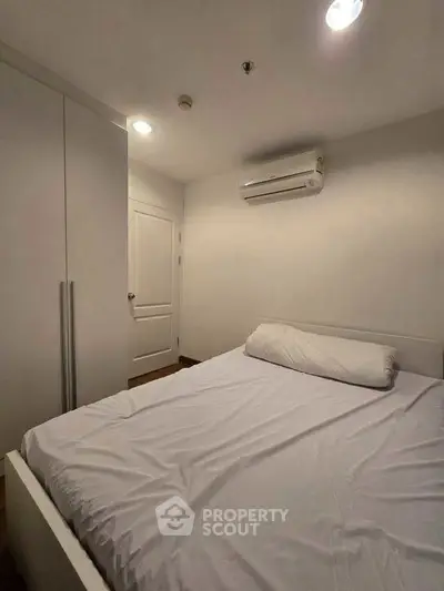 Cozy bedroom with white bedding and air conditioning, perfect for restful nights.