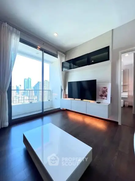 Modern living room with sleek TV setup and city view balcony