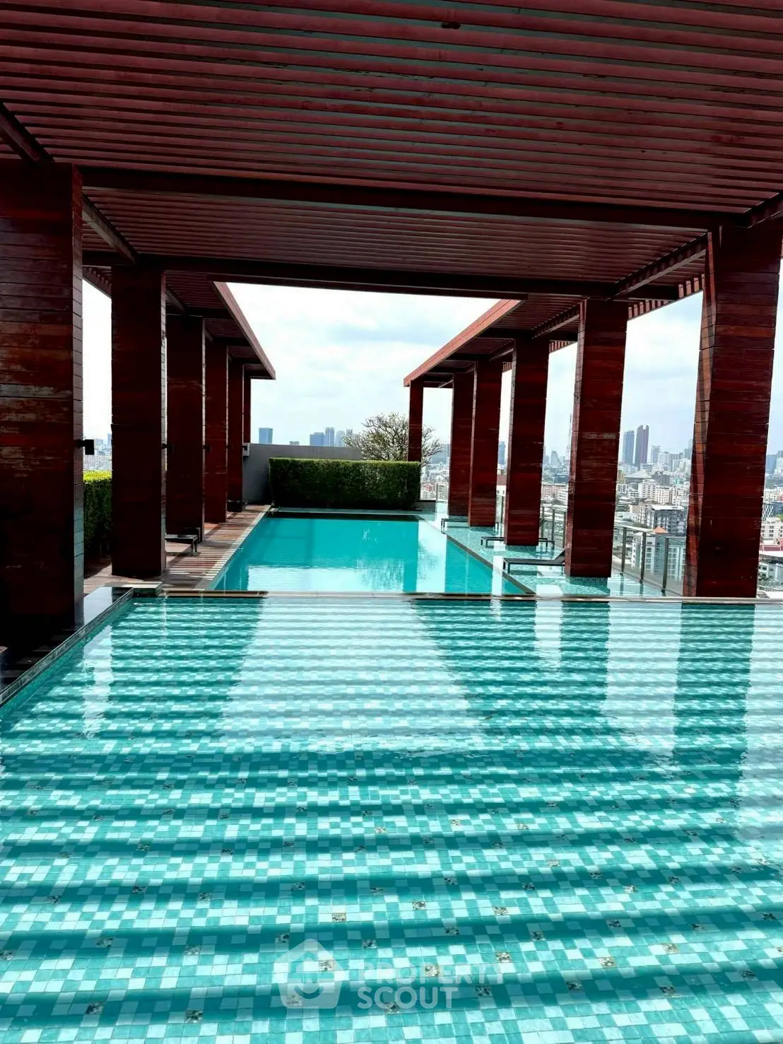 Luxurious rooftop pool with stunning city views and modern wooden pergola design.