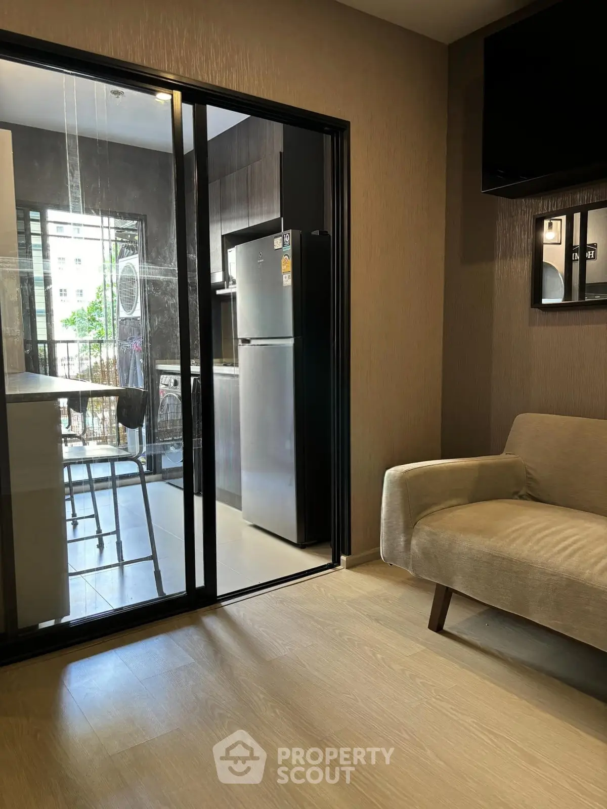 Modern apartment with open kitchen and cozy living area, featuring sleek appliances and stylish decor.