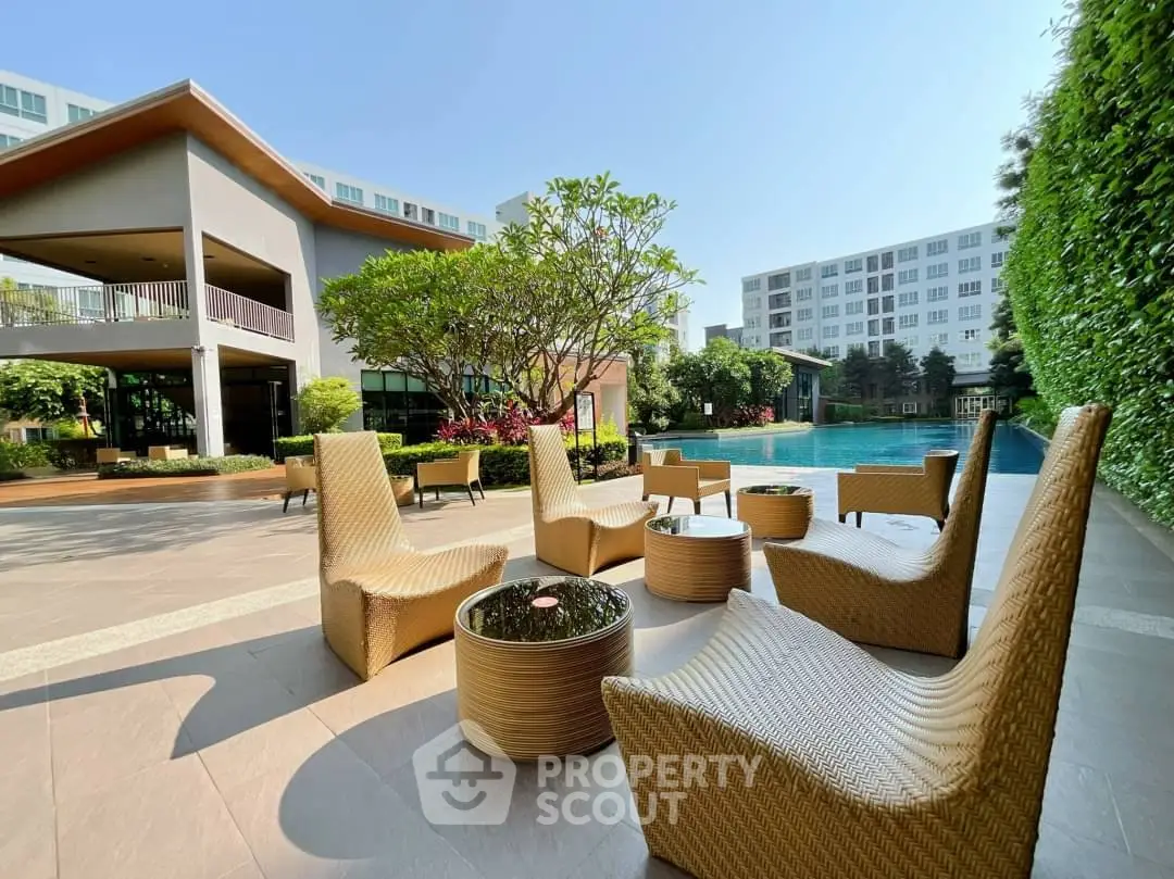 Luxurious outdoor pool area with modern seating and lush greenery in a high-end residential complex.