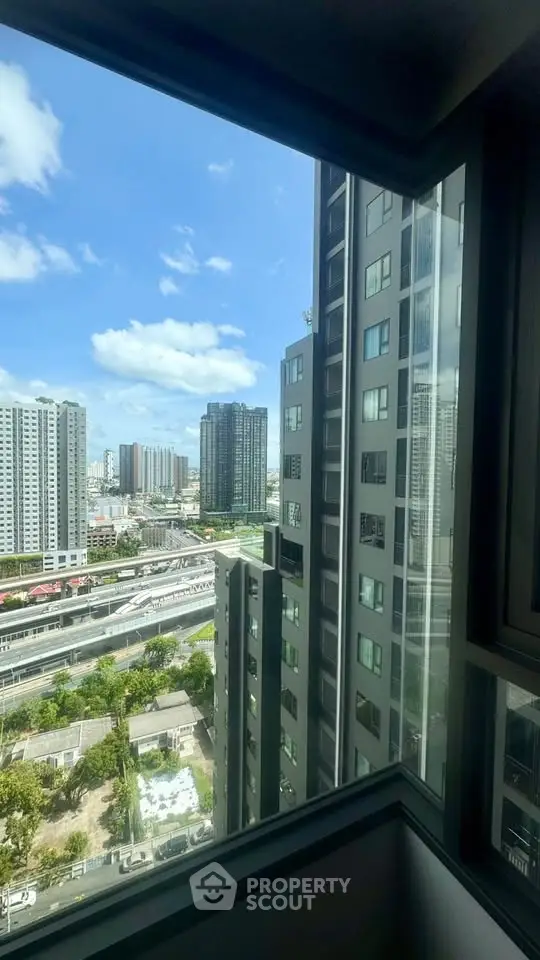 Stunning urban view from high-rise apartment window showcasing city skyline and modern architecture.
