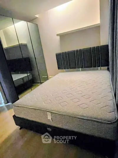 Spacious bedroom with mirrored wardrobe and modern bed frame