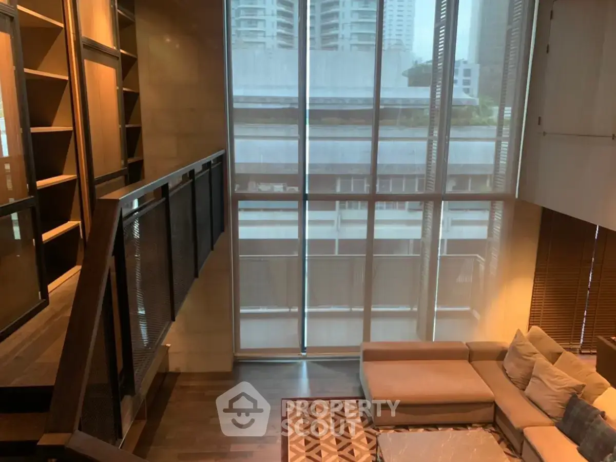 Spacious modern living room with high ceilings and large windows offering city views.
