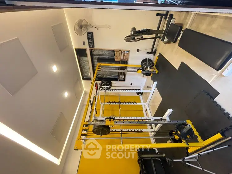 Modern home gym with yellow accents and fitness equipment
