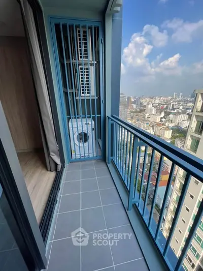 Modern balcony with city view and washing machine in high-rise apartment.