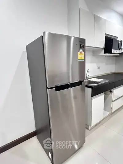 Modern kitchen with sleek stainless steel fridge and minimalist design.