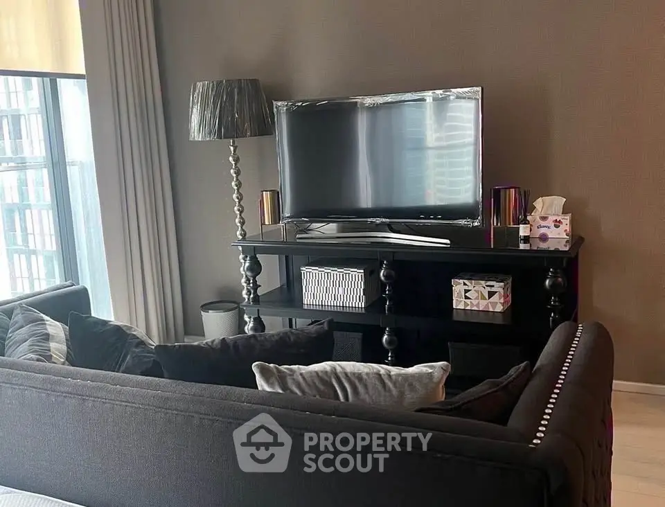 Stylish living room with modern decor and large TV, perfect for relaxation.