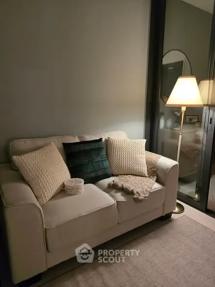 Cozy living room with elegant sofa and ambient lighting, perfect for relaxation.