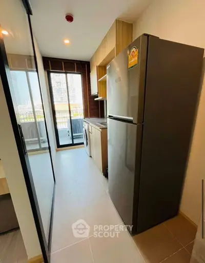 Modern kitchen with sleek appliances and balcony view in urban apartment