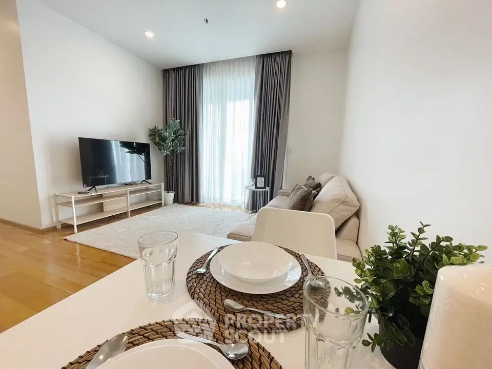 Modern living room with stylish decor and natural light, featuring a cozy sofa and entertainment setup.