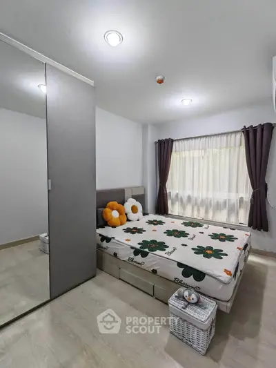 Cozy bedroom with modern decor, large window, and ample storage space in a stylish apartment.